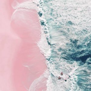 Pink Beach Aerial Photography captures the waves braking around small rocks and in the same way rolling on a pink sand beach.