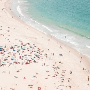 Aerial view of a vibrant summer beach with colorful umbrellas and people enjoying the shoreline