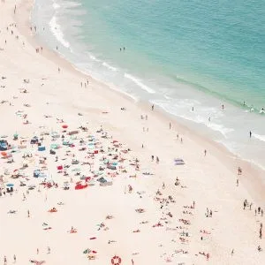 Aerial view of a vibrant summer beach with colorful umbrellas and people enjoying the shoreline